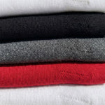 Detail shot of classic ribbed knee high compression socks in red, white, black, marled grey.