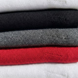 Detail shot of classic ribbed knee high compression socks in red, white, black, marled grey.