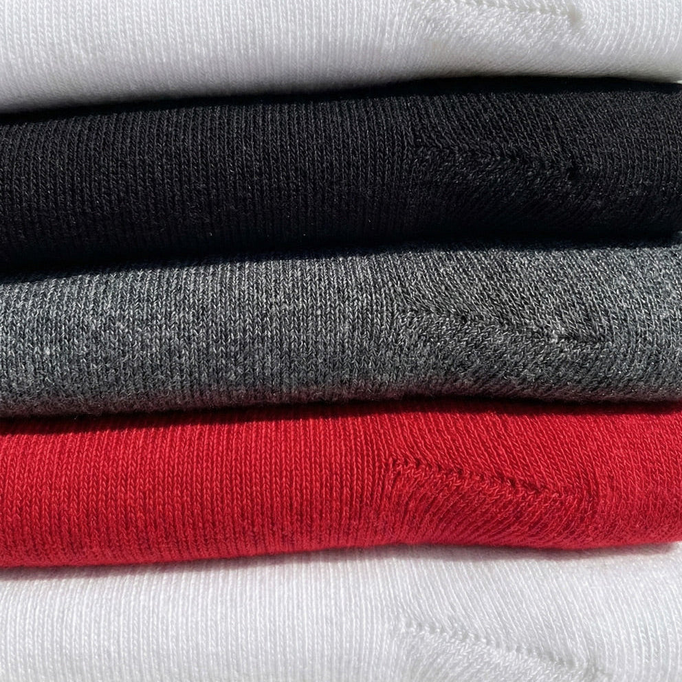 Detail shot of classic ribbed knee high compression socks in red, white, black, marled grey.