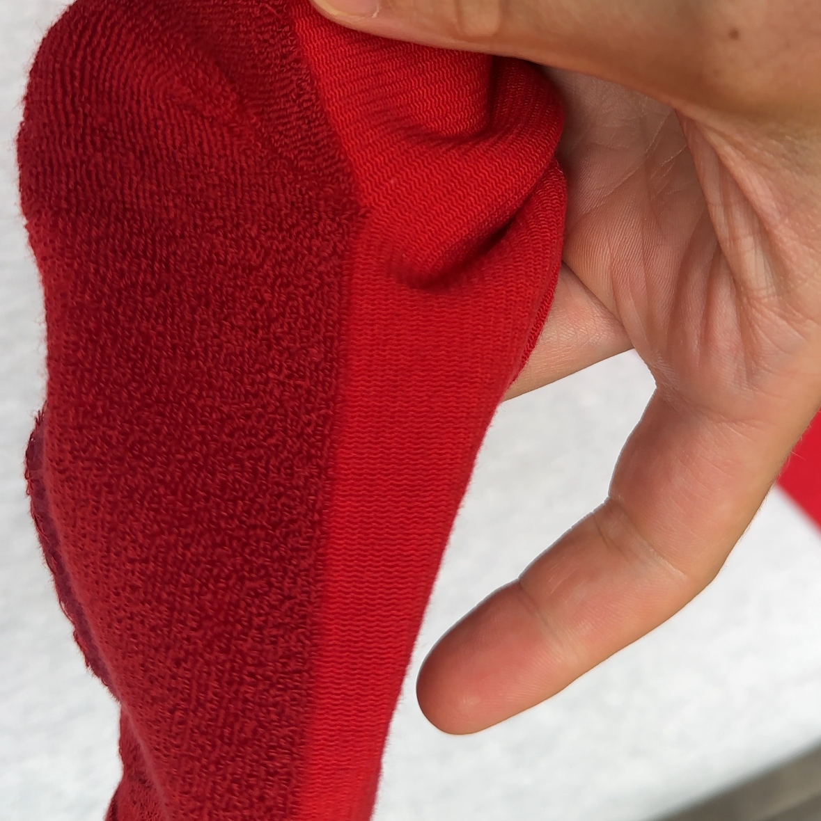 The inside of a red knee high compression socks featuring full terry looped foot cushion