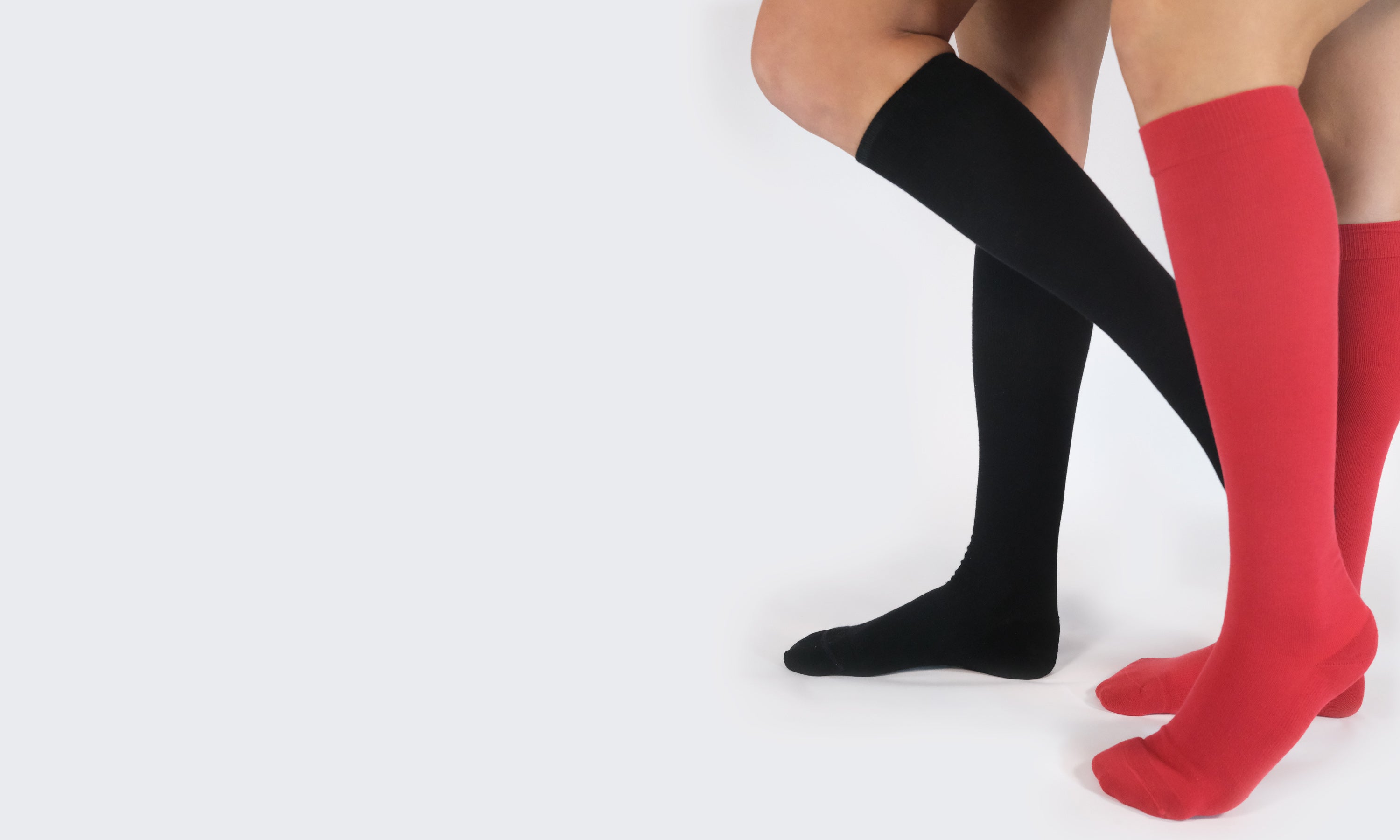 Black and red knee-high compression socks on a white background