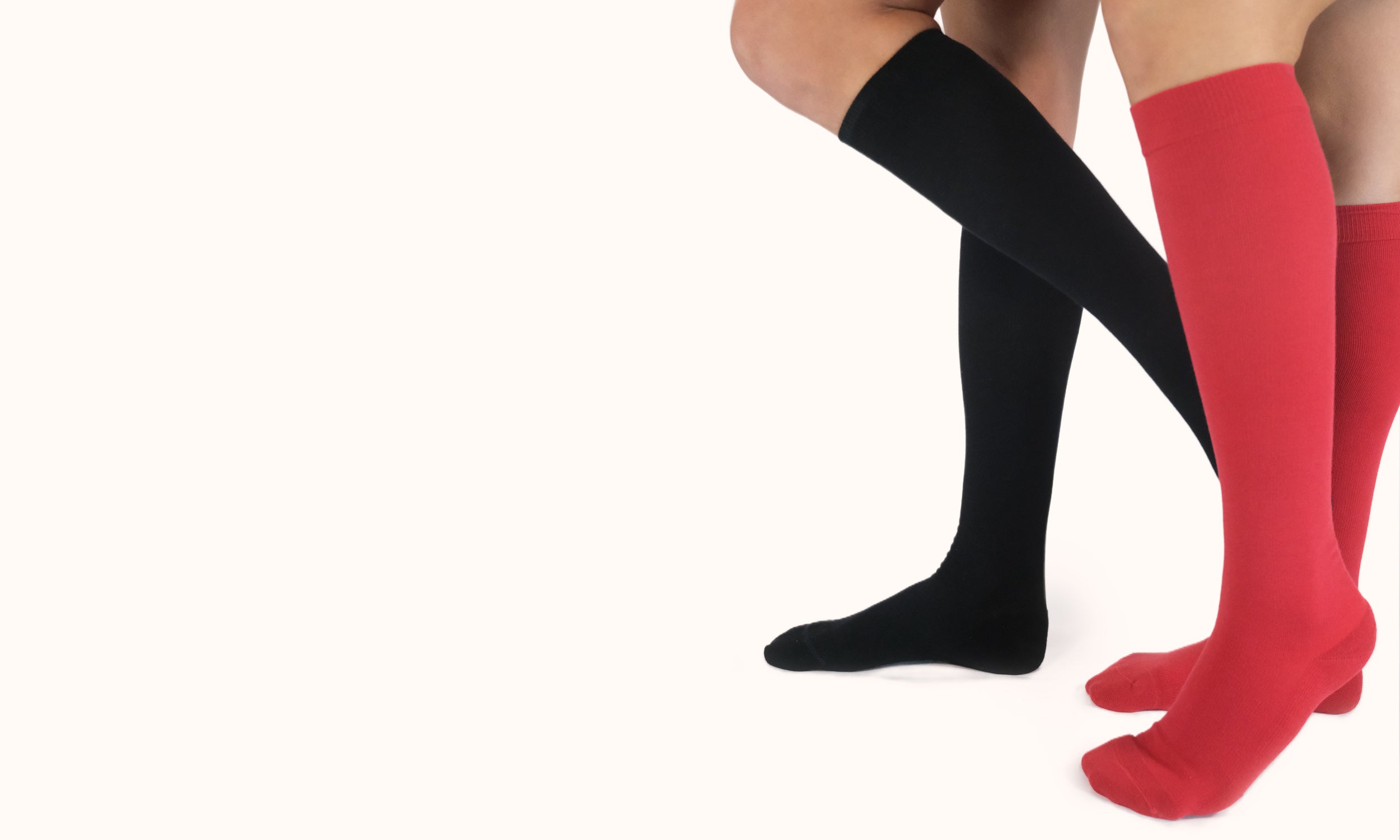 Black and red knee-high compression socks on a white background