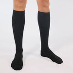Black knee-high socks worn by a person on a white background