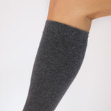 Close up detail of a gray knee-high compression sock on a white background