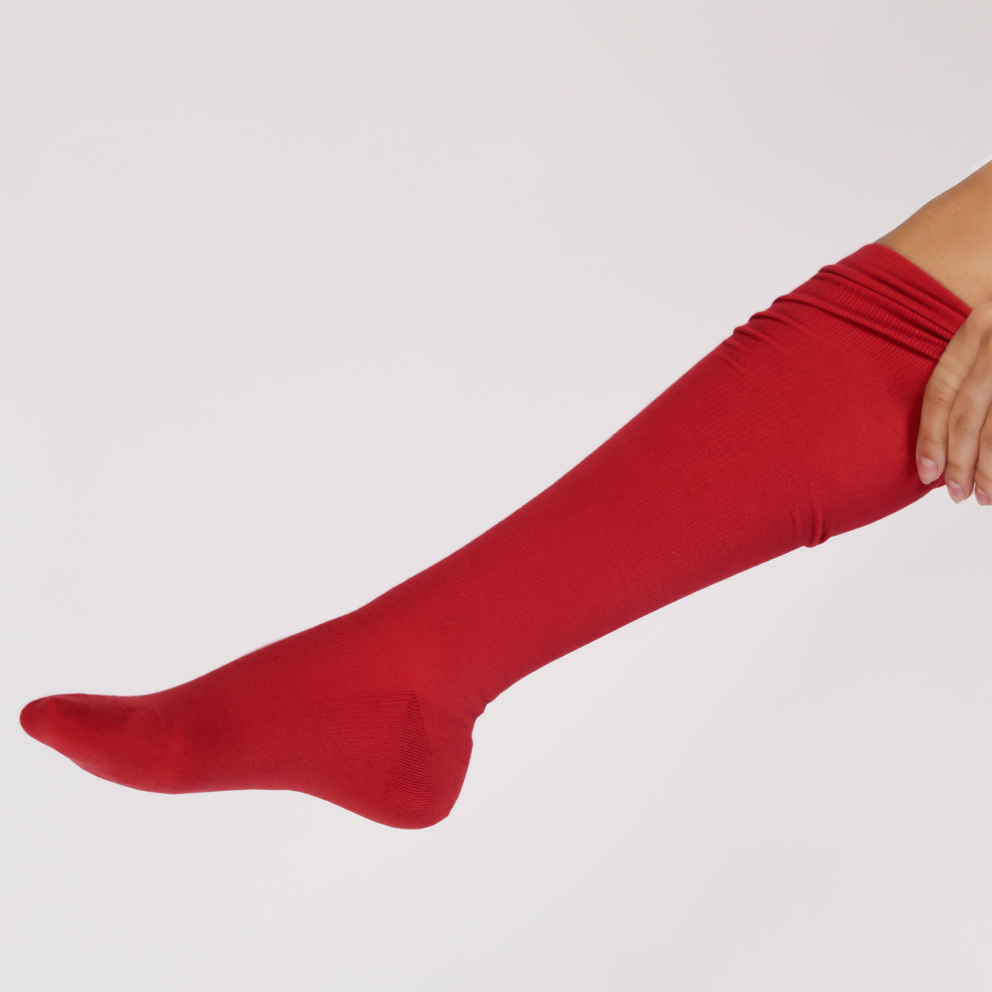Red knee-high compression sock on a light gray background