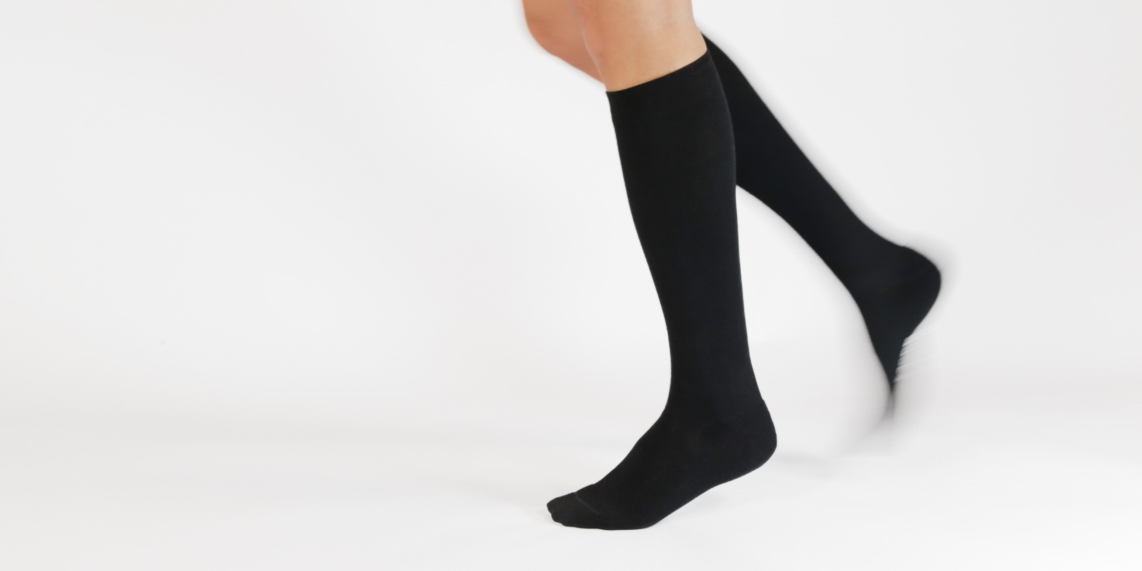 Black knee-high compression socks on a white background